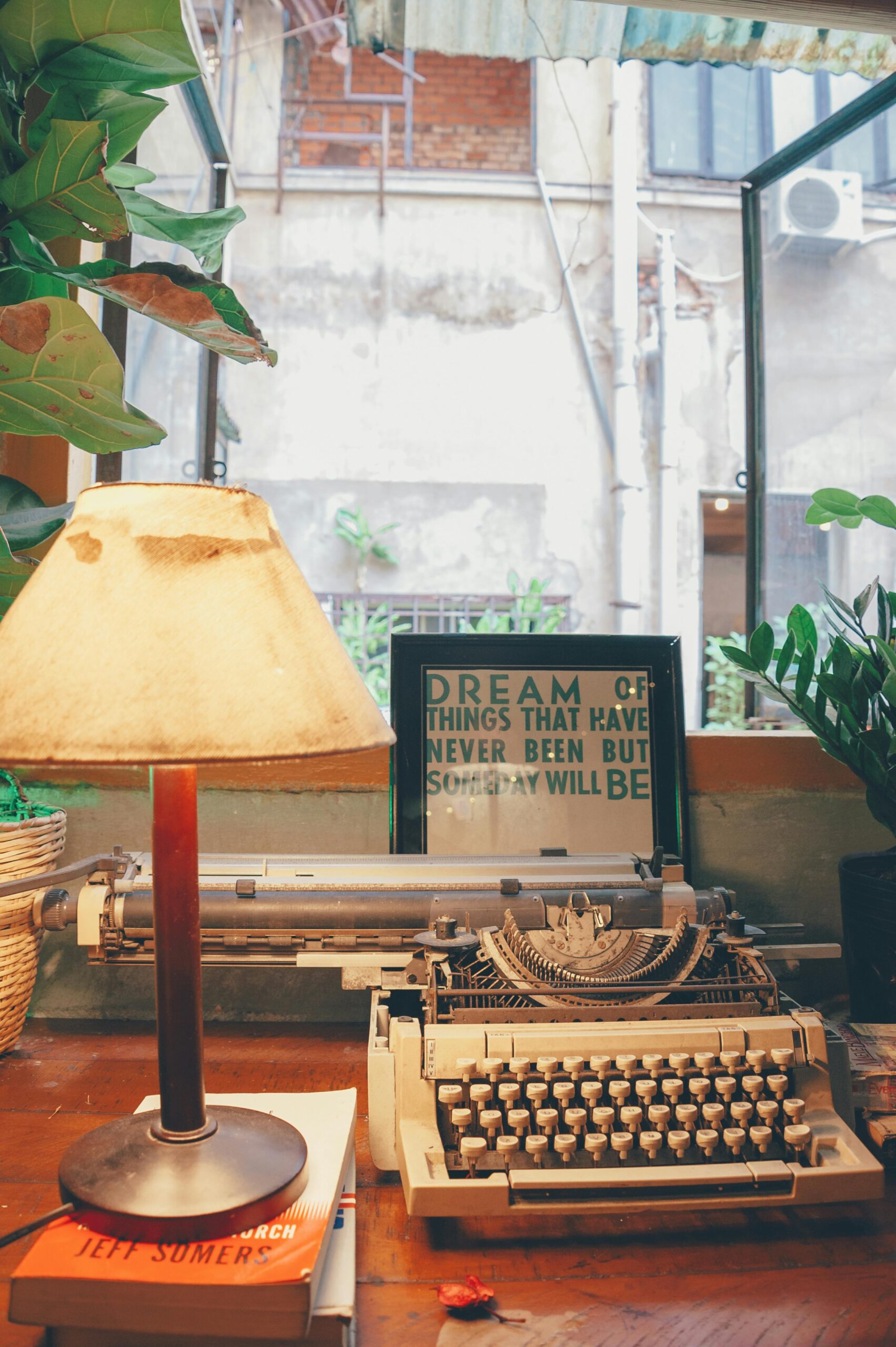 A cozy vintage setting with a typewriter, lamp, and open window, evoking nostalgia and creativity.